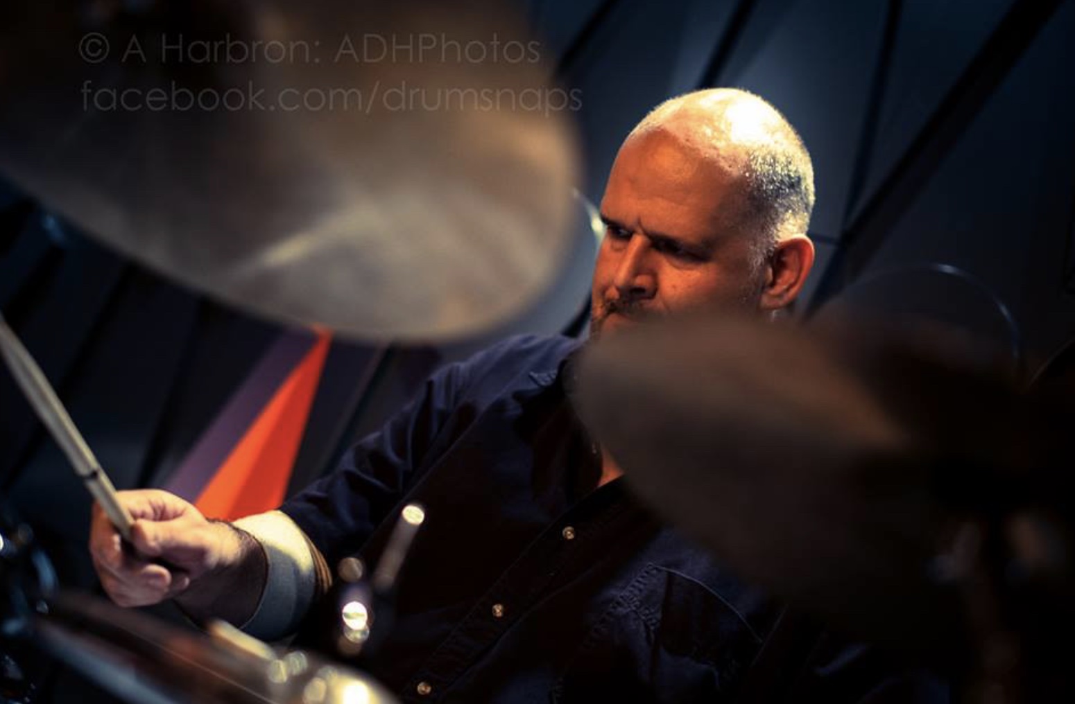 Close-up of Ian Backhouse playing drums live